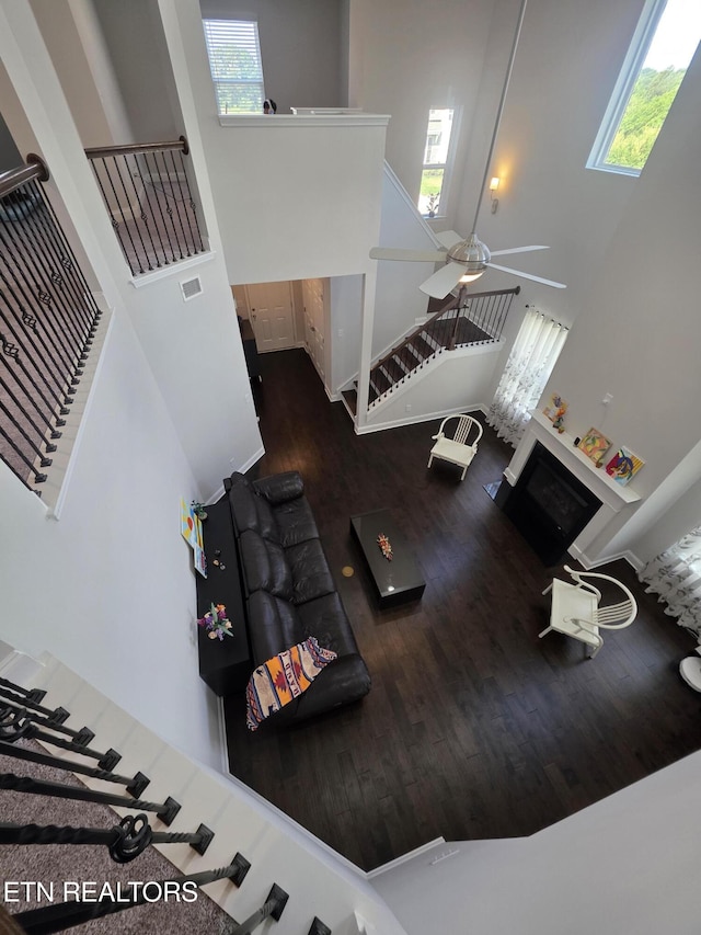12751 Baltica Ln, Farragut, TN 37934 - living room featuring a towering ceiling, wood finished floors, healthy amount of natural light, stairway, and a fireplace
