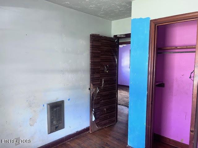 unfurnished bedroom with visible vents, wood finished floors, and a textured ceiling