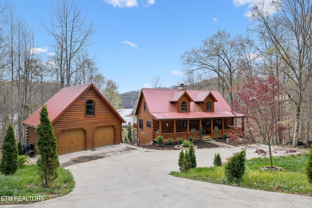 log-style house featuring a chimney, log siding, an outbuilding, metal roof, and a porch
