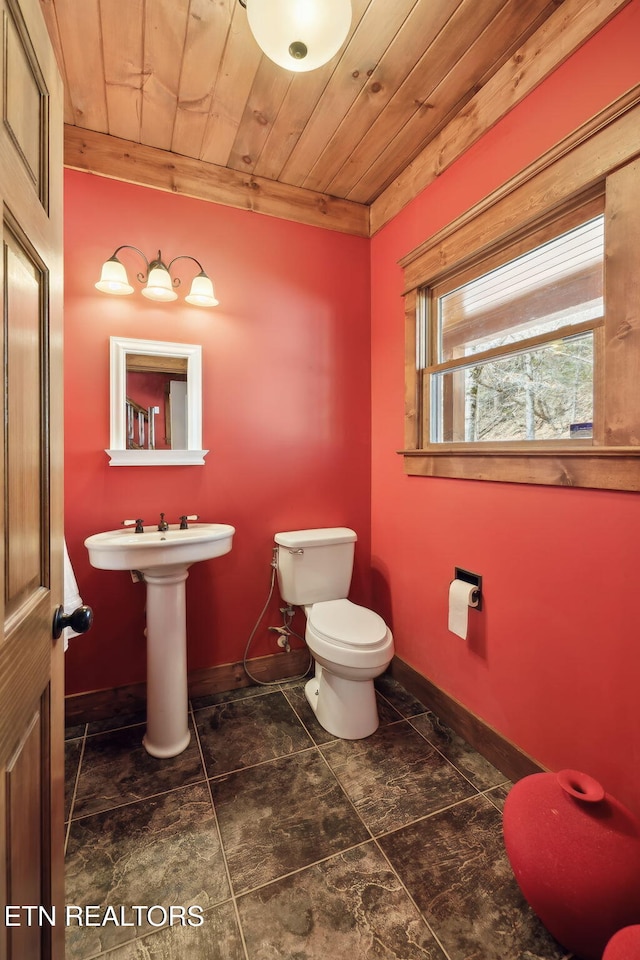 bathroom featuring baseboards, toilet, and wood ceiling