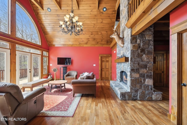 living area featuring high vaulted ceiling, a chandelier, a fireplace, wood finished floors, and wood ceiling