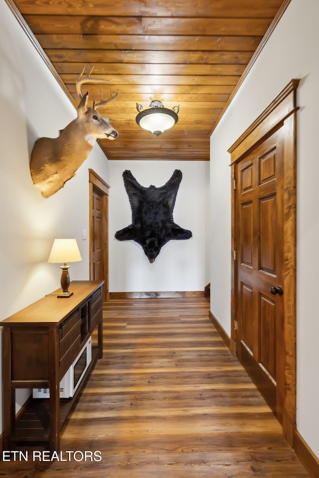 hall with crown molding, baseboards, wood finished floors, and wooden ceiling