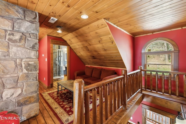 living area featuring vaulted ceiling, an upstairs landing, wooden ceiling, wood-type flooring, and visible vents