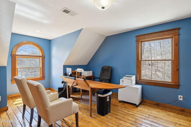 office space with hardwood / wood-style floors, baseboards, vaulted ceiling, and visible vents