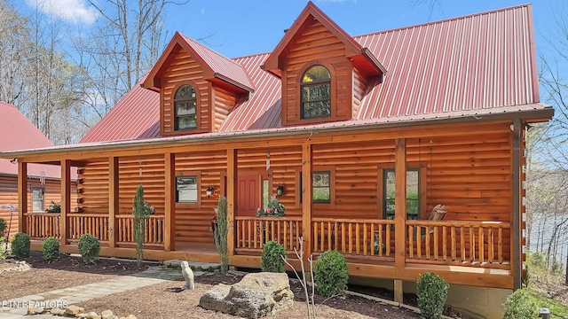 log home featuring metal roof and a porch