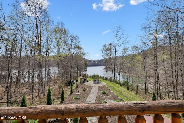 property view of water featuring an outdoor fire pit and a view of trees
