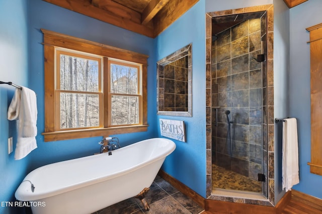 bathroom with a freestanding tub, a stall shower, and baseboards