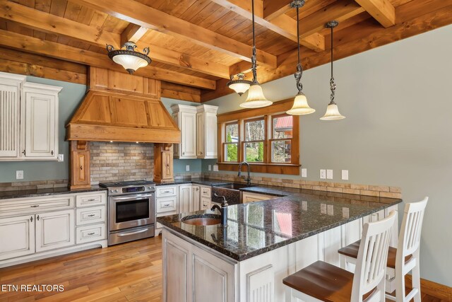 kitchen featuring wooden ceiling, a sink, a peninsula, custom exhaust hood, and gas stove