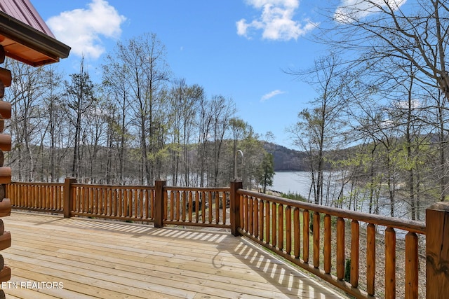 deck with a water view and a view of trees