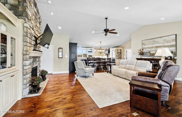 8207 Washington Pike, Corryton, TN 37721 - living area featuring lofted ceiling, ceiling fan with notable chandelier, baseboards, dark wood-style floors, and a stone fireplace