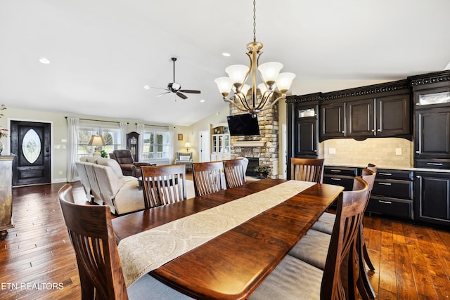 8207 Washington Pike, Corryton, TN 37721 - dining space with vaulted ceiling, ceiling fan with notable chandelier, baseboards, dark wood finished floors, and a fireplace