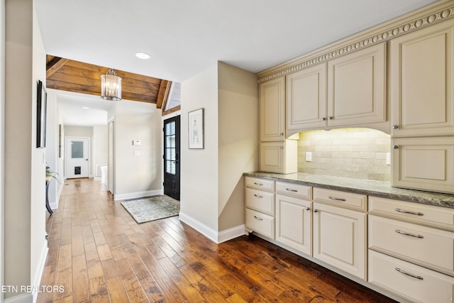 8207 Washington Pike, Corryton, TN 37721 - kitchen featuring backsplash, cream cabinets, dark wood-style floors, and baseboards