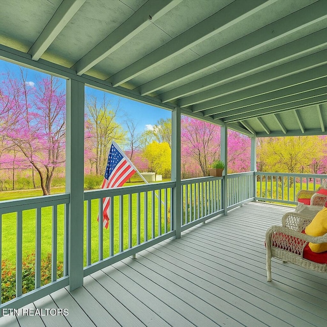 wooden terrace featuring a lawn