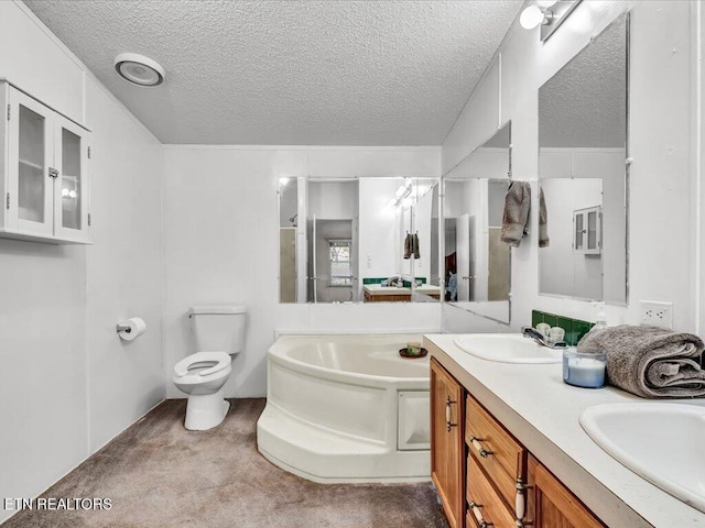 bathroom with a bath, a textured ceiling, a sink, and toilet
