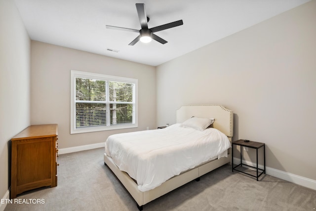 bedroom featuring baseboards, light carpet, and ceiling fan