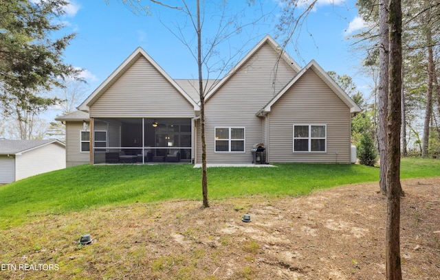 rear view of property featuring a yard and a sunroom