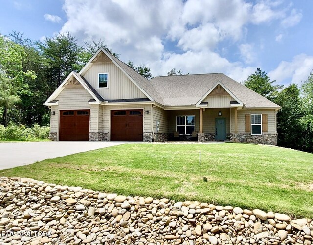 craftsman inspired home with stone siding, board and batten siding, concrete driveway, and a front yard
