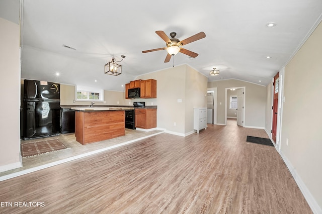 kitchen featuring a ceiling fan, open floor plan, lofted ceiling, light wood-style flooring, and black appliances