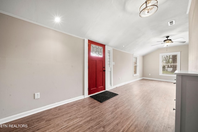 foyer featuring lofted ceiling, baseboards, ceiling fan, visible vents, and wood finished floors