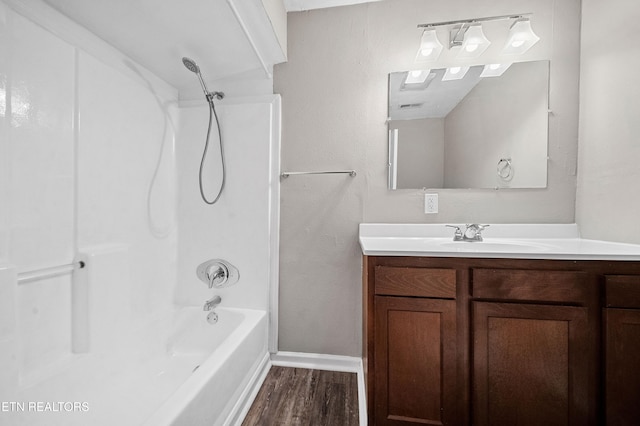 bathroom with bathing tub / shower combination, vanity, and wood finished floors