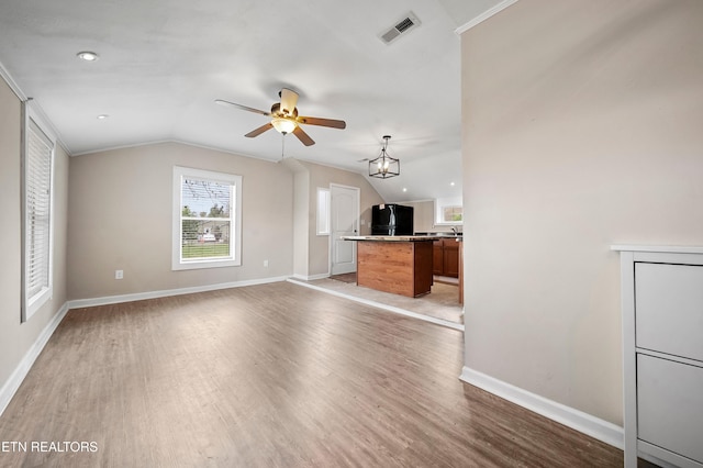 unfurnished living room featuring vaulted ceiling, visible vents, light wood-type flooring, and a ceiling fan