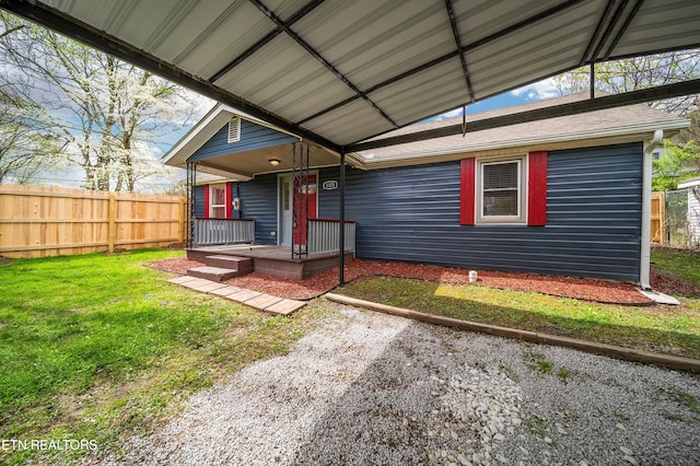 view of front of property with covered porch, fence, and a front yard