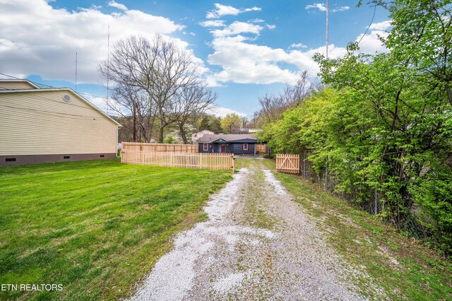view of yard featuring driveway and fence