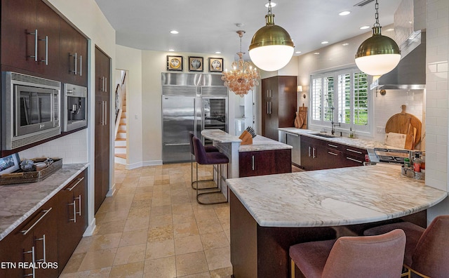 11901 S Fox Den Dr, Knoxville, TN 37934 - kitchen with built in appliances, a breakfast bar area, tasteful backsplash, recessed lighting, and a peninsula