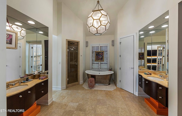 11901 S Fox Den Dr, Knoxville, TN 37934 - full bath featuring a freestanding tub, two vanities, high vaulted ceiling, baseboards, and a stall shower