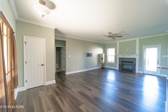 unfurnished living room with a tile fireplace, crown molding, baseboards, a ceiling fan, and dark wood-type flooring