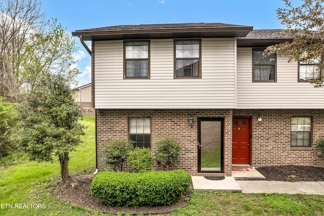 view of front of property with a front yard and brick siding