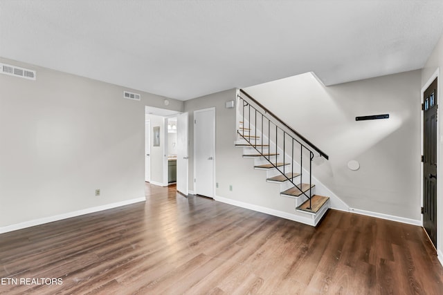 interior space with visible vents, wood finished floors, and stairs