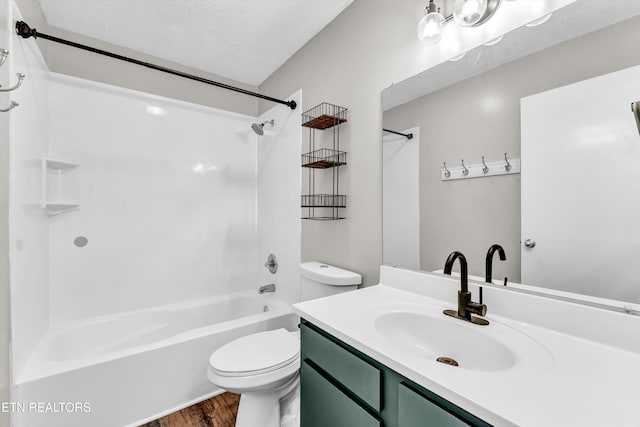 full bath with toilet, a textured ceiling, bathtub / shower combination, vanity, and wood finished floors