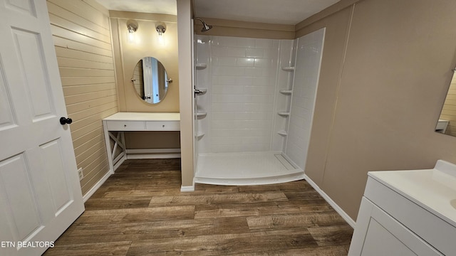 full bath with vanity, tiled shower, and wood finished floors