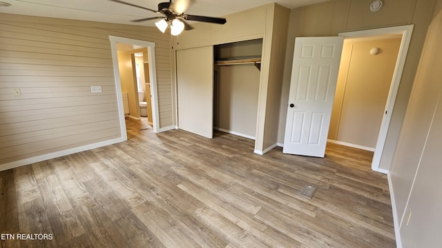 unfurnished bedroom with a closet, baseboards, and wood finished floors