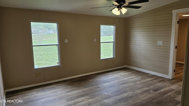 spare room with baseboards, ceiling fan, and wood finished floors