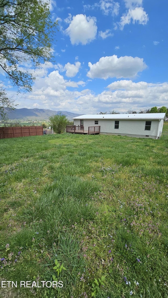 view of yard with a wooden deck and fence