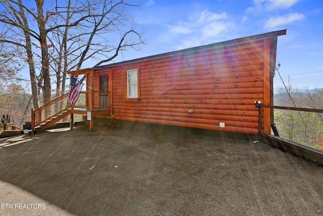 rear view of property featuring log veneer siding