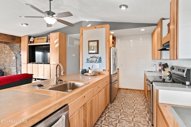 kitchen with a sink, light floors, appliances with stainless steel finishes, under cabinet range hood, and visible vents