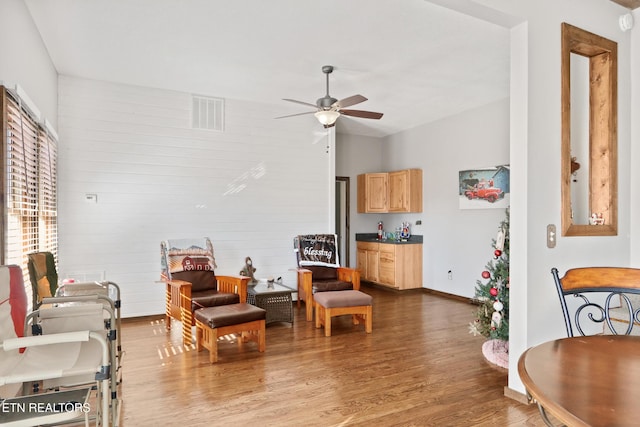 living area featuring vaulted ceiling, baseboards, visible vents, ceiling fan, and dark wood-style flooring