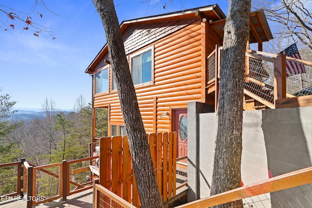 view of side of property featuring faux log siding and a deck