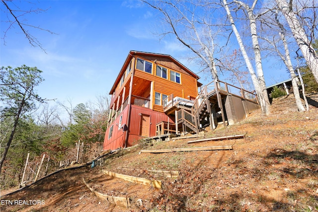 rear view of house with stairs and a wooden deck