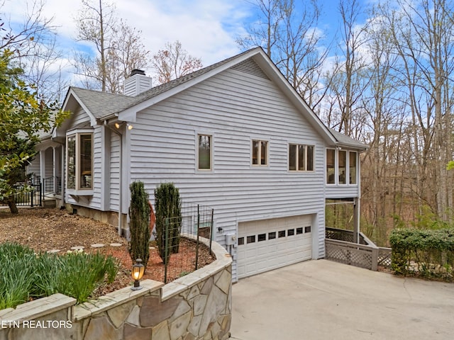 12 Wessex Ct, Crossville, TN 38558 - view of property exterior with an attached garage, a chimney, concrete driveway, and a shingled roof