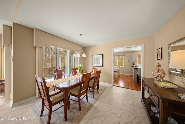 12 Wessex Ct, Crossville, TN 38558 - dining space with baseboards, marble finish floor, and a notable chandelier