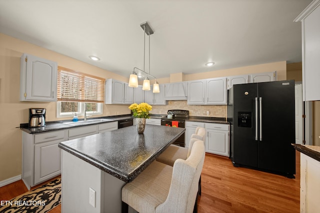 12 Wessex Ct, Crossville, TN 38558 - kitchen featuring a sink, black appliances, dark countertops, and light wood-style floors