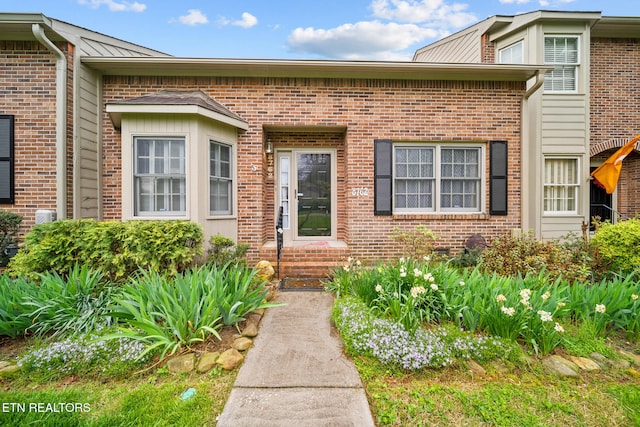 doorway to property with brick siding