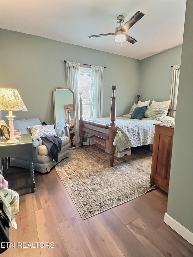 bedroom featuring baseboards, wood finished floors, and ceiling fan
