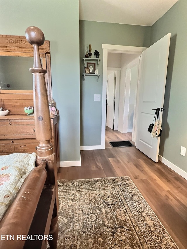 bedroom featuring baseboards and wood finished floors