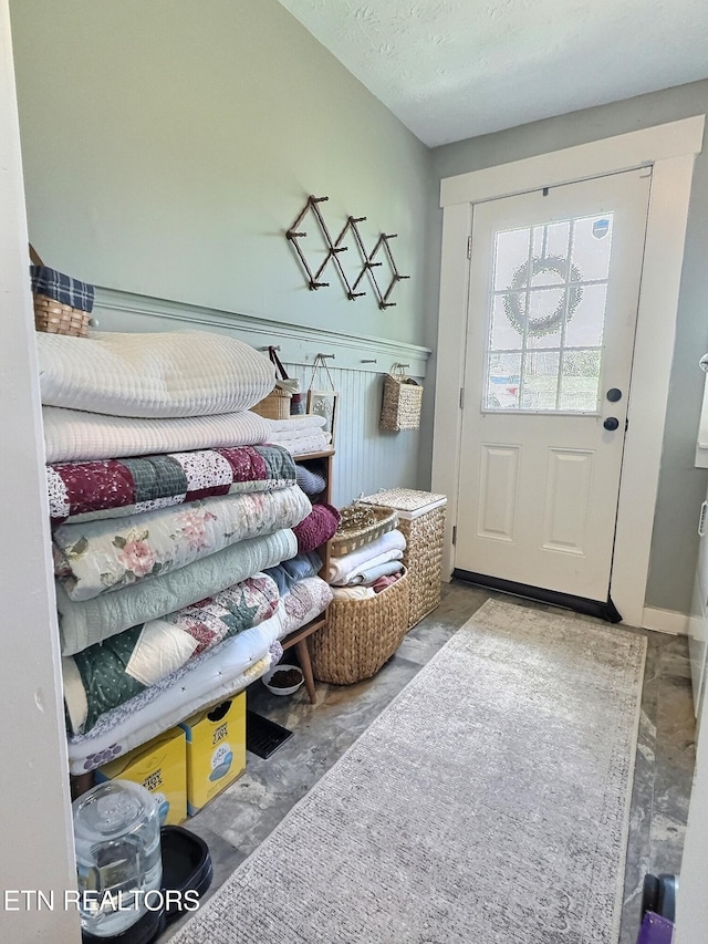 mudroom with unfinished concrete floors and a textured ceiling