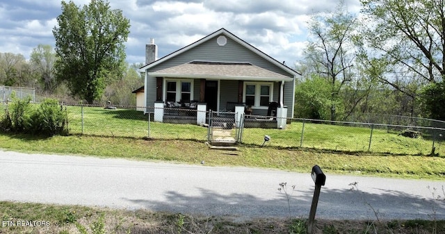 bungalow-style house featuring a front yard, a porch, a fenced front yard, and a chimney